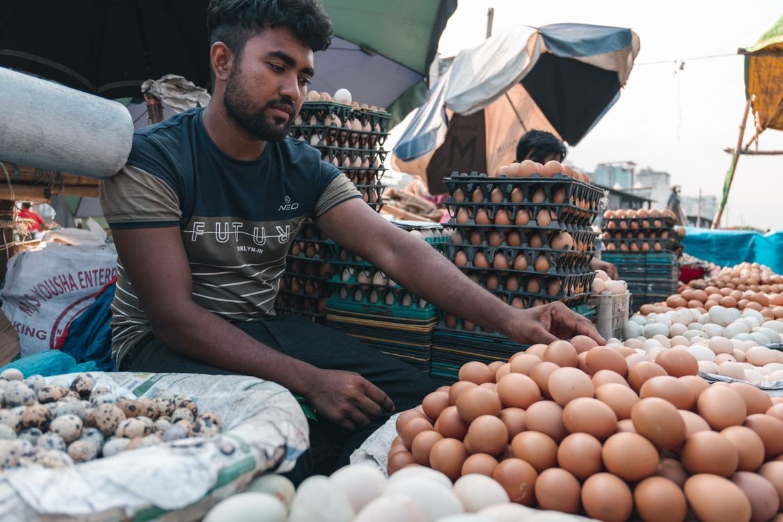 Marchand vendant des plateaux d’œufs frais sur un marché local
